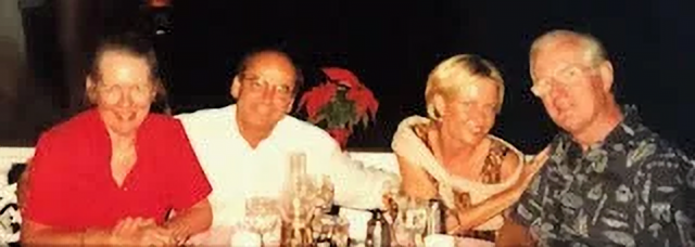 Picture of Chrystal, Don, his wife and Merrick seated at a table at night.